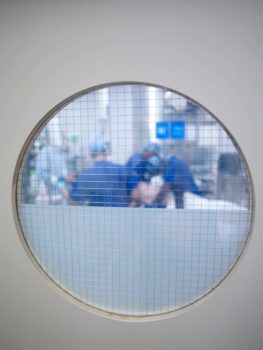 Photograph of a surgery taken through an operating theatre window